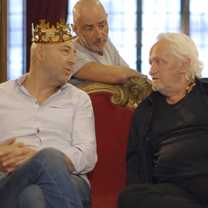 Trois hommes sur un trône rouge, l'un coiffé d'une couronne dorée, spot web réalisé par Sonacom