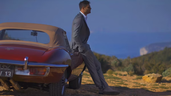 Homme en costume s'éloignant d'un cabriolet ancien, « Le Grand Saut » avec Florent Manaudou par Sonacom