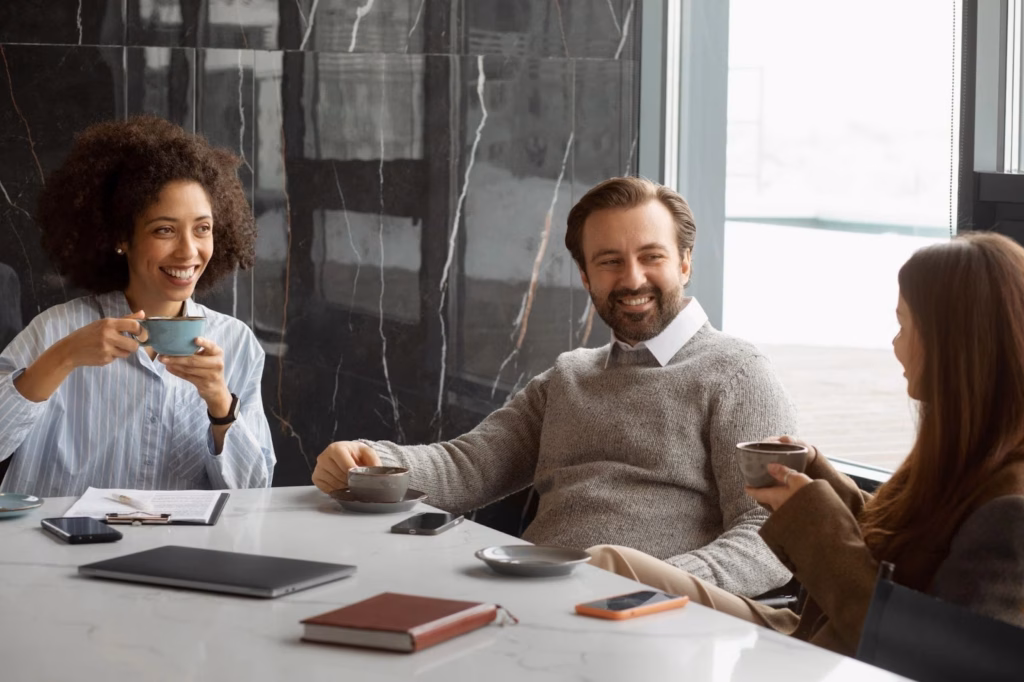 Réunion d'entreprise conviviale autour d'une table, collaborateurs souriants