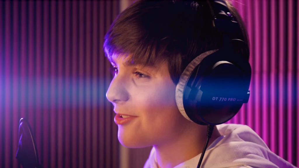 Jeune chanteur au casque en studio sous une lumière violette, clip « Envie de chanter » de Gabriel réalisé par Sonacom