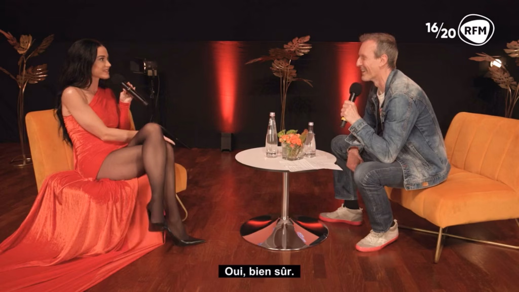Katy Perry en robe rouge interviewée par Pat Angeli sur le plateau de RFM, captation réalisée par Sonacom