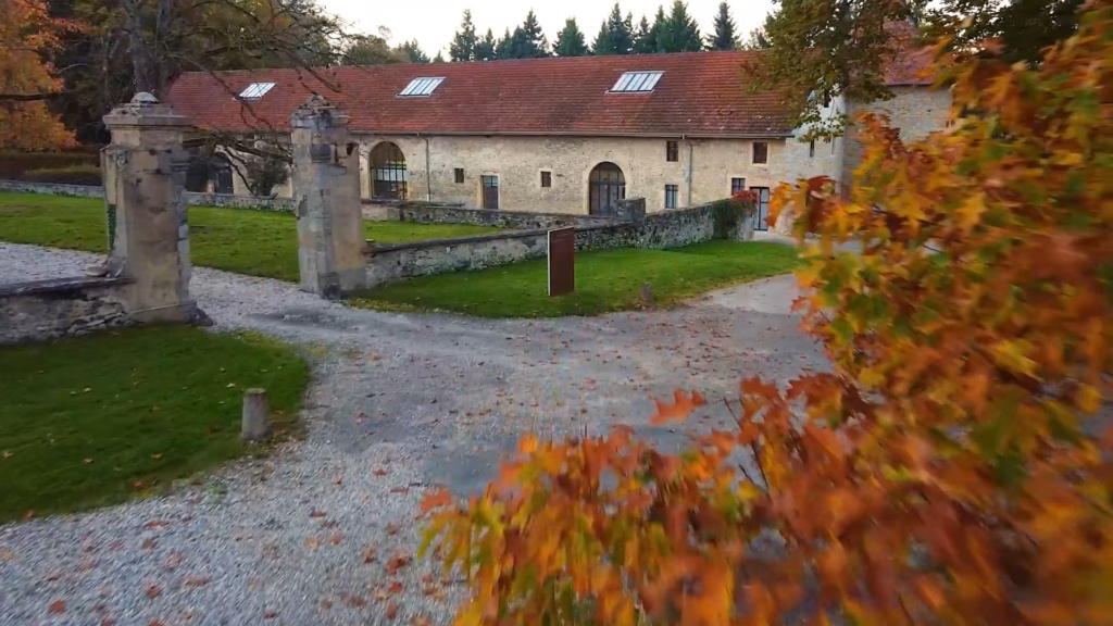 Cour d'un domaine en pierre et feuillage d'automne, film Tokenyz réalisé par Sonacom